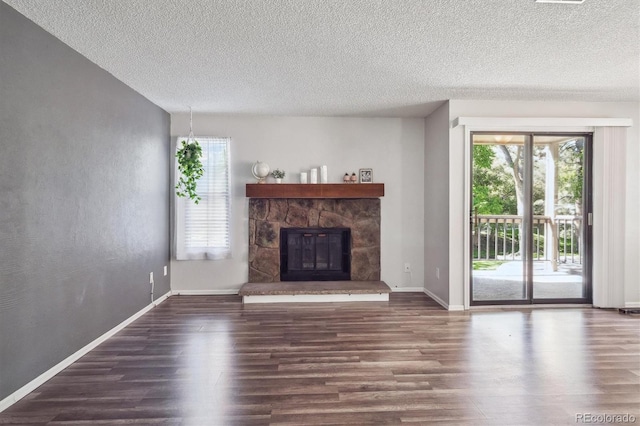 10950 W Florida Ave Unit 314, Lakewood, CO 80232 - unfurnished living room featuring wood finished floors, plenty of natural light, a textured ceiling, and a stone fireplace