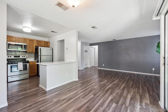 10950 W Florida Ave Unit 314, Lakewood, CO 80232 - kitchen featuring appliances with stainless steel finishes, dark wood-style flooring, light countertops, open floor plan, and a textured ceiling