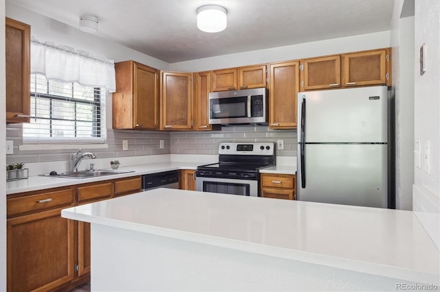 10950 W Florida Ave Unit 314, Lakewood, CO 80232 - kitchen featuring stainless steel appliances, light countertops, brown cabinets, and tasteful backsplash