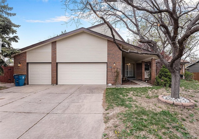 view of front of property with a garage, fence, driveway, and brick siding