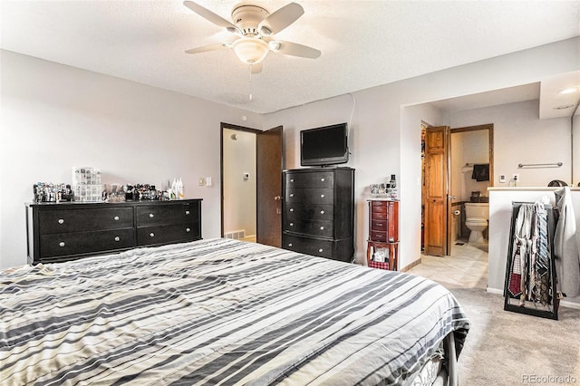 bedroom featuring light colored carpet, a ceiling fan, baseboards, and ensuite bathroom