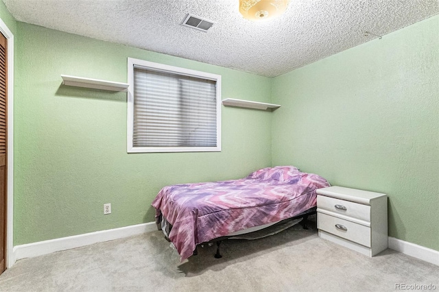 bedroom featuring baseboards, carpet flooring, a textured ceiling, and visible vents