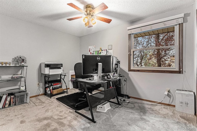 carpeted office space featuring baseboards, a ceiling fan, and a textured ceiling