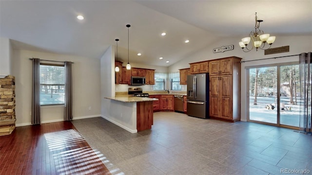 kitchen featuring kitchen peninsula, appliances with stainless steel finishes, an inviting chandelier, and pendant lighting