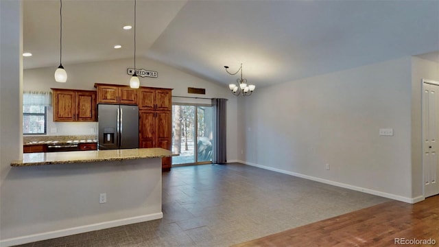 kitchen featuring pendant lighting, stainless steel refrigerator with ice dispenser, light stone countertops, tasteful backsplash, and a chandelier