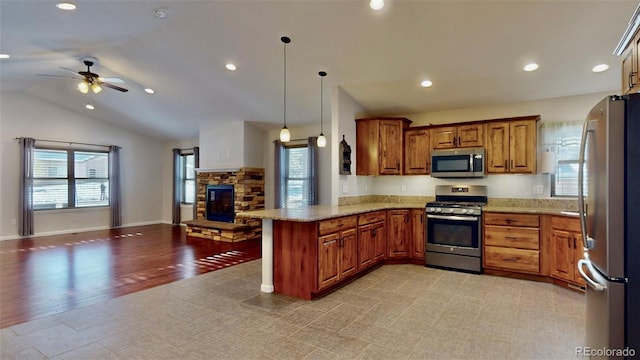 kitchen featuring kitchen peninsula, stainless steel appliances, vaulted ceiling, ceiling fan, and decorative light fixtures