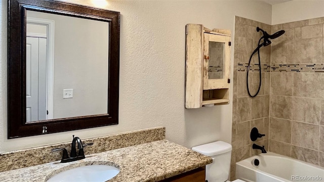 full bathroom with vanity, toilet, and tiled shower / bath combo