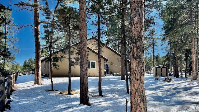 view of snow covered exterior with a storage shed