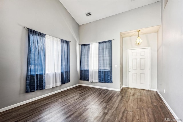 entrance foyer featuring a healthy amount of sunlight, dark hardwood / wood-style flooring, and high vaulted ceiling