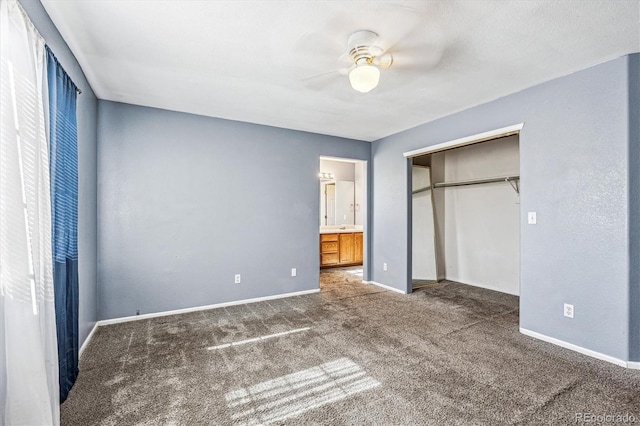 unfurnished bedroom featuring ensuite bathroom, carpet, ceiling fan, and a closet