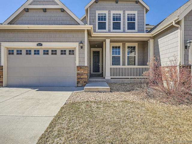 craftsman inspired home featuring an attached garage, stone siding, a porch, and concrete driveway