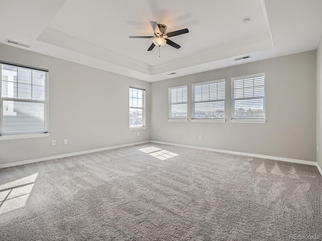 unfurnished room with carpet, a raised ceiling, visible vents, and baseboards