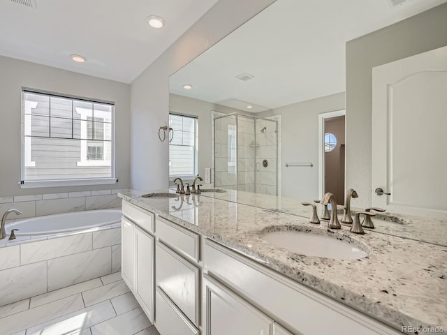 bathroom with double vanity, a sink, a shower stall, and a bath