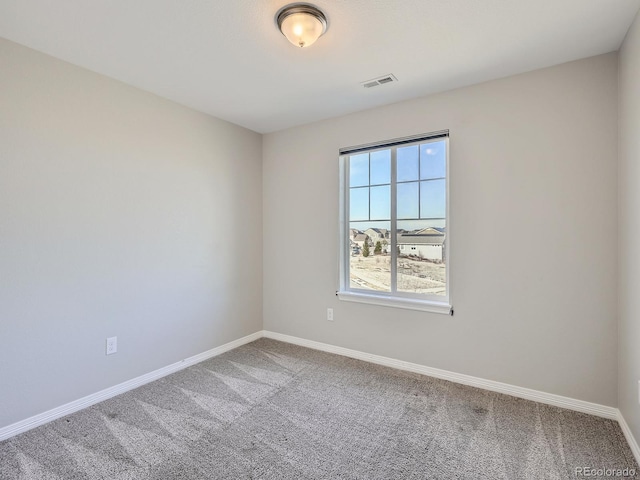 carpeted empty room featuring visible vents and baseboards