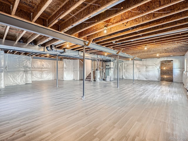 unfinished below grade area with gas water heater and wood finished floors