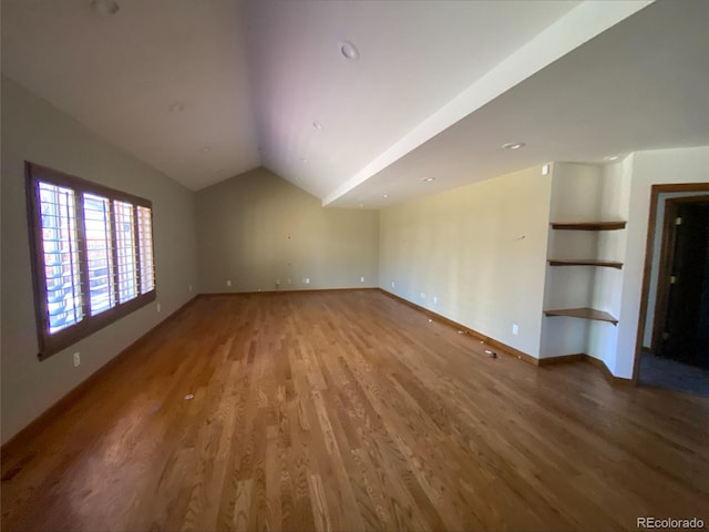 unfurnished living room featuring light wood-style floors, lofted ceiling, and baseboards