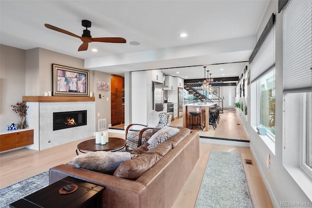 living area featuring recessed lighting, a tile fireplace, visible vents, and ceiling fan