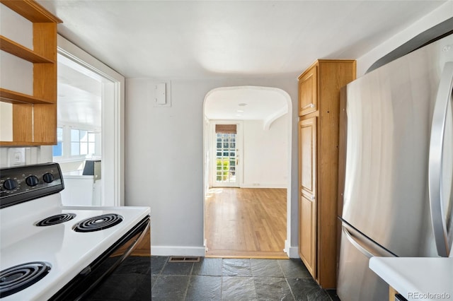 kitchen with visible vents, range with electric cooktop, stone finish flooring, freestanding refrigerator, and open shelves