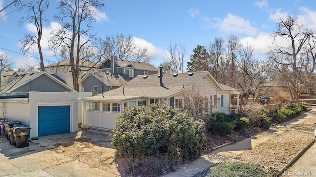 view of side of property with a residential view, a garage, and driveway