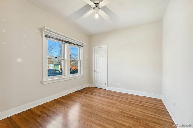 unfurnished room with baseboards, light wood finished floors, and ceiling fan