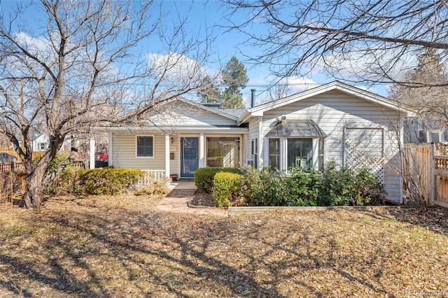 view of front of home with a porch and fence
