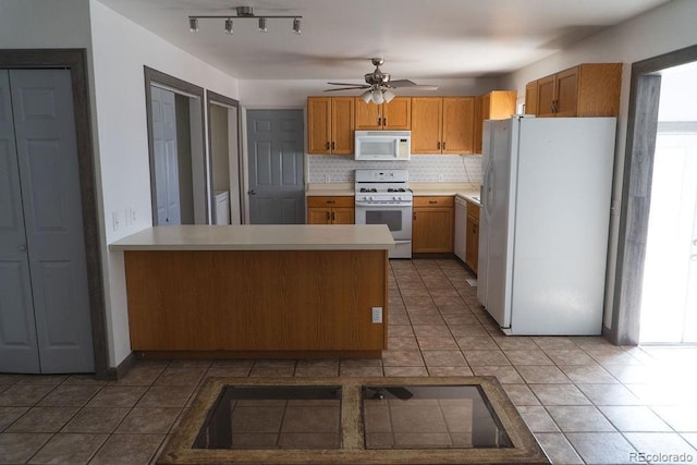 kitchen featuring decorative backsplash, white appliances, a peninsula, and light countertops