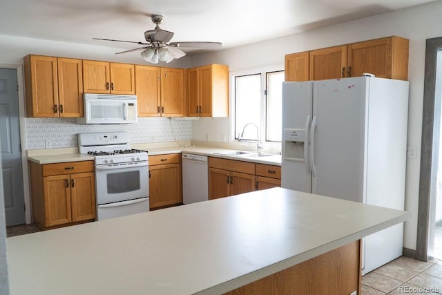 kitchen with white appliances, light tile patterned floors, a sink, light countertops, and tasteful backsplash