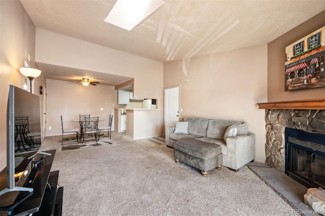 living room featuring carpet, a textured ceiling, a fireplace, and ceiling fan