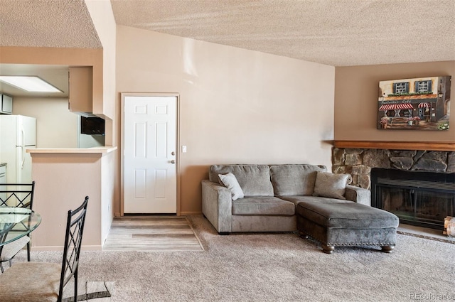 living room featuring a fireplace, a textured ceiling, and carpet flooring