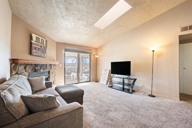 living room featuring carpet flooring, a skylight, a textured ceiling, high vaulted ceiling, and a fireplace