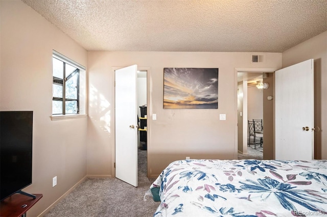 bedroom with carpet floors and a textured ceiling