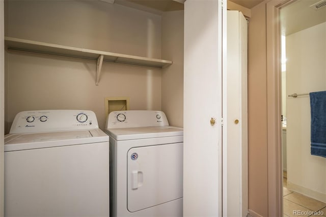 washroom with independent washer and dryer and light tile patterned floors