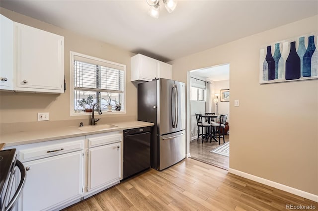 kitchen with stainless steel appliances, a sink, light wood-type flooring, white cabinets, and light countertops