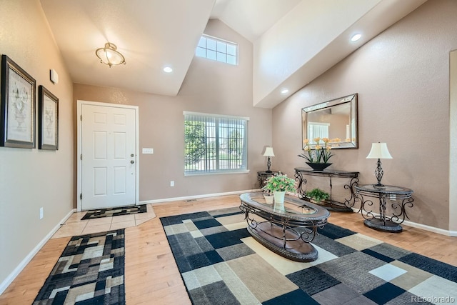 entrance foyer featuring high vaulted ceiling and light wood-type flooring