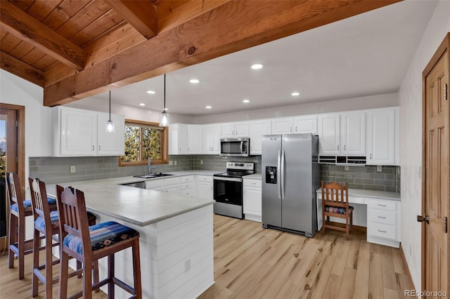 820 Schulze Ranch Rd, Westcliffe, CO 81252 - kitchen with stainless steel appliances, a peninsula, light wood-style flooring, beamed ceiling, and light countertops