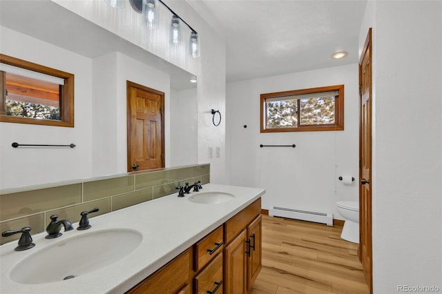 820 Schulze Ranch Rd, Westcliffe, CO 81252 - bathroom with baseboard heating, wood finished floors, toilet, double vanity, and recessed lighting