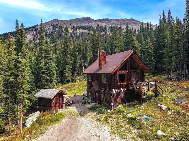 10 Bullion Mine Rd, Keystone, CO 80435 - view of front of home featuring a view of trees, a chimney, a mountain view, and a storage unit
