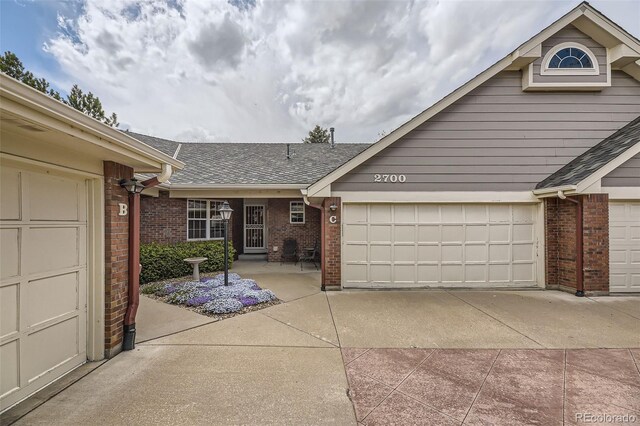 2700 W Riverwalk Cir Unit C, Littleton, CO 80123 - single story home with brick siding, a shingled roof, and a garage