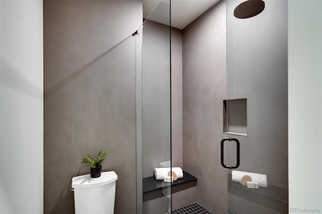 bathroom with a shower with shower door and toilet