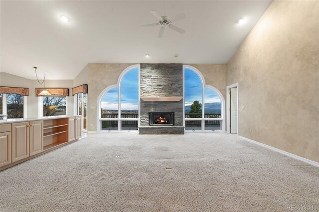 265 Ox Yoke Way, Monument, CO 80132 - unfurnished living room with lofted ceiling, a ceiling fan, a fireplace, carpet flooring, and baseboards