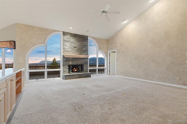 265 Ox Yoke Way, Monument, CO 80132 - unfurnished living room featuring a ceiling fan, carpet flooring, a fireplace, high vaulted ceiling, and baseboards