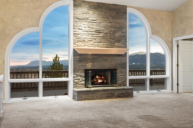 265 Ox Yoke Way, Monument, CO 80132 - unfurnished living room with a mountain view, carpet, and a stone fireplace