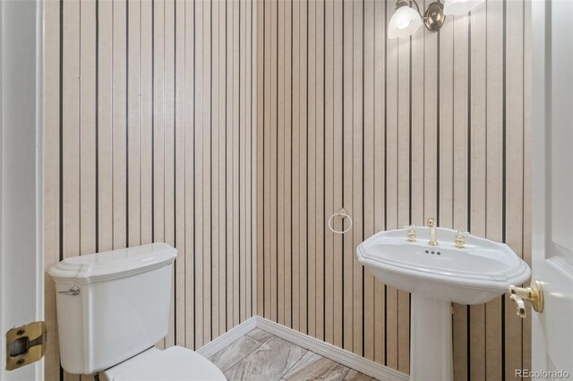 265 Ox Yoke Way, Monument, CO 80132 - half bath featuring toilet, wood walls, and marble finish floors