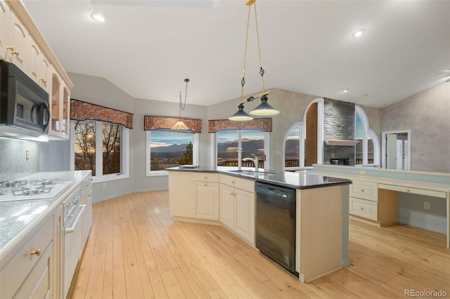 265 Ox Yoke Way, Monument, CO 80132 - kitchen with black appliances, a sink, lofted ceiling, a center island with sink, and light wood-style floors