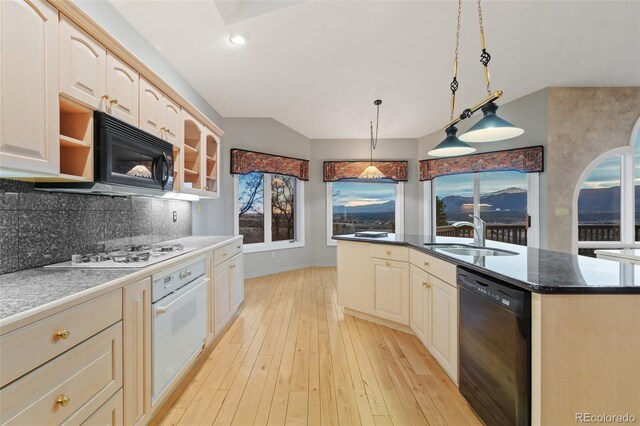 265 Ox Yoke Way, Monument, CO 80132 - kitchen featuring black appliances, light wood finished floors, a sink, tasteful backsplash, and a kitchen island with sink