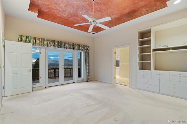 265 Ox Yoke Way, Monument, CO 80132 - unfurnished bedroom featuring access to exterior, carpet floors, connected bathroom, a tray ceiling, and baseboards