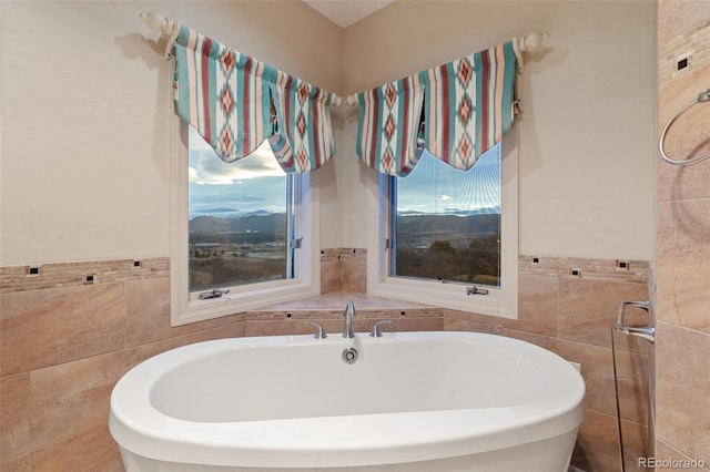 265 Ox Yoke Way, Monument, CO 80132 - bathroom featuring tile walls, a freestanding tub, and a wainscoted wall