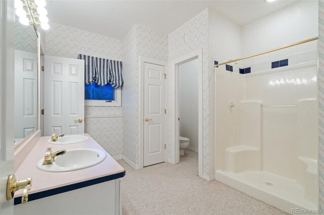 265 Ox Yoke Way, Monument, CO 80132 - full bath featuring wallpapered walls, double vanity, toilet, baseboards, and a shower