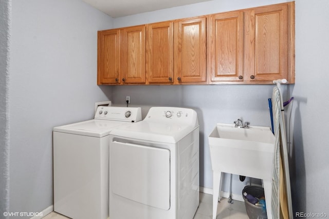 washroom featuring light tile patterned floors, cabinets, and washer and clothes dryer