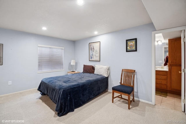 bedroom with baseboards, recessed lighting, ensuite bath, and light colored carpet